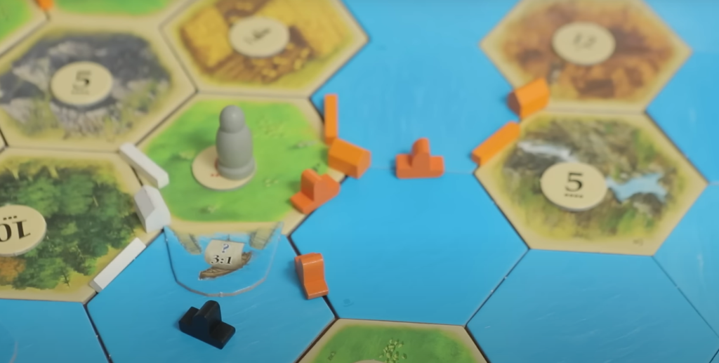 harbor, knight and ship pieces on the Catan coast tiles